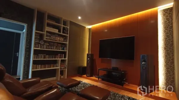 Detached House for sale in Prawet, Bangkok - Cozy home theater with leather recliners, built-in bookcase, large TV and ambient lighting.