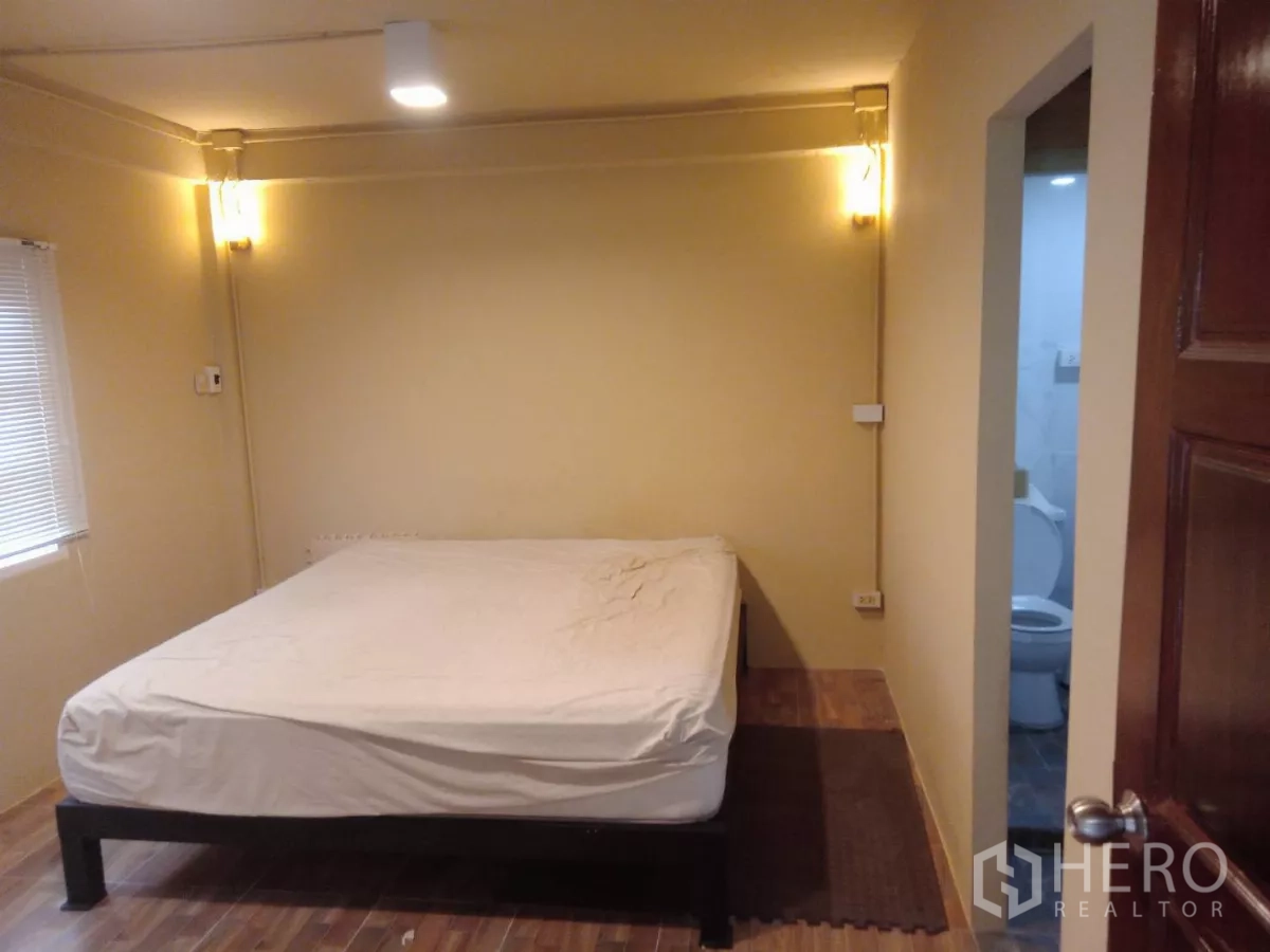 Detached House for rent in Phaya Thai, Bangkok - Bedroom with bed and window lighting, plus door to ensuite bathroom.