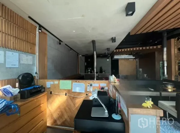 Retail Space for rent in Watthana, Bangkok - Service counter with wood finish and POS, looking across an open-plan dining area with ventilation pipes.