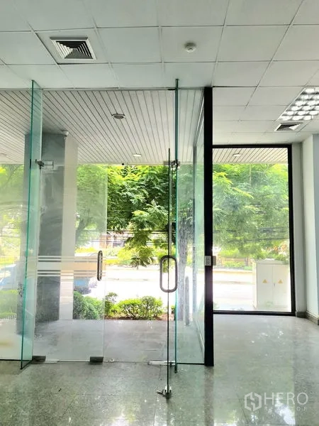 Retail Space for rent in Sathon, Bangkok - Clear glass double doors at the shop entrance with views of a tree-lined walkway outside.