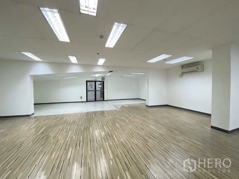 Retail Space for rent in Khlong Toei, Bangkok - Spacious shop area with ceiling light panels, mirrored wall, and wall-mounted air conditioning.