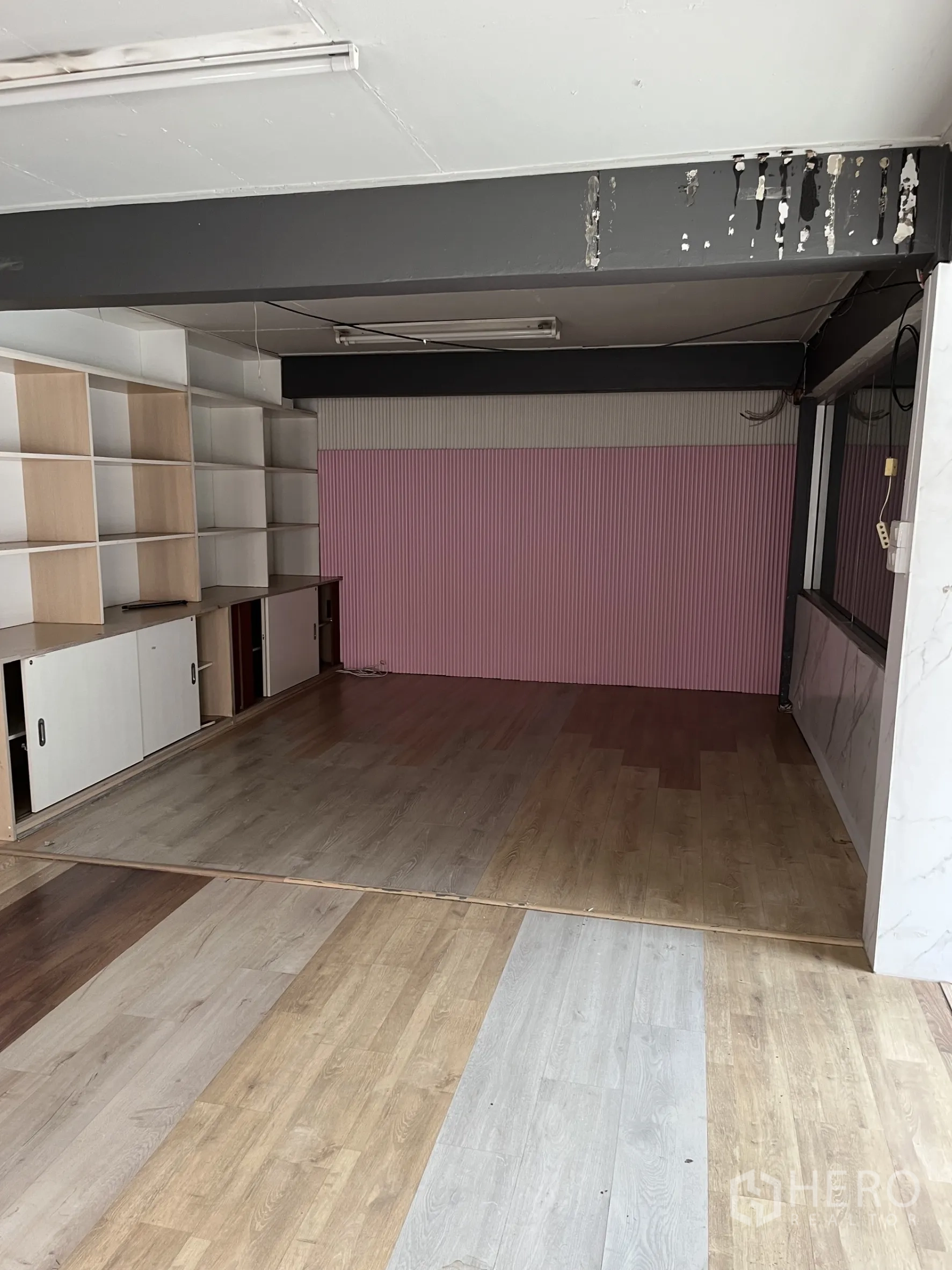 Warehouse for rent in Bangkok - Workspace with built-in shelving, pink feature wall and multi-tone wood floors.