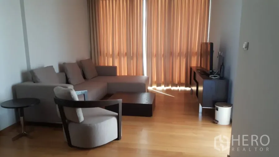 Condominium for rent in Watthana, Bangkok - Modern kitchen with glossy cabinetry, double-door refrigerator and a six-seat dining table.