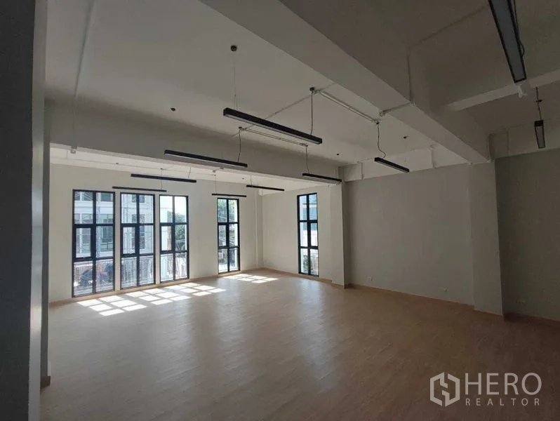 带办公室的家 出租在Bang Kapi, Bangkok - 大面积开放式办公空间，层高高、线性灯具与落地窗。