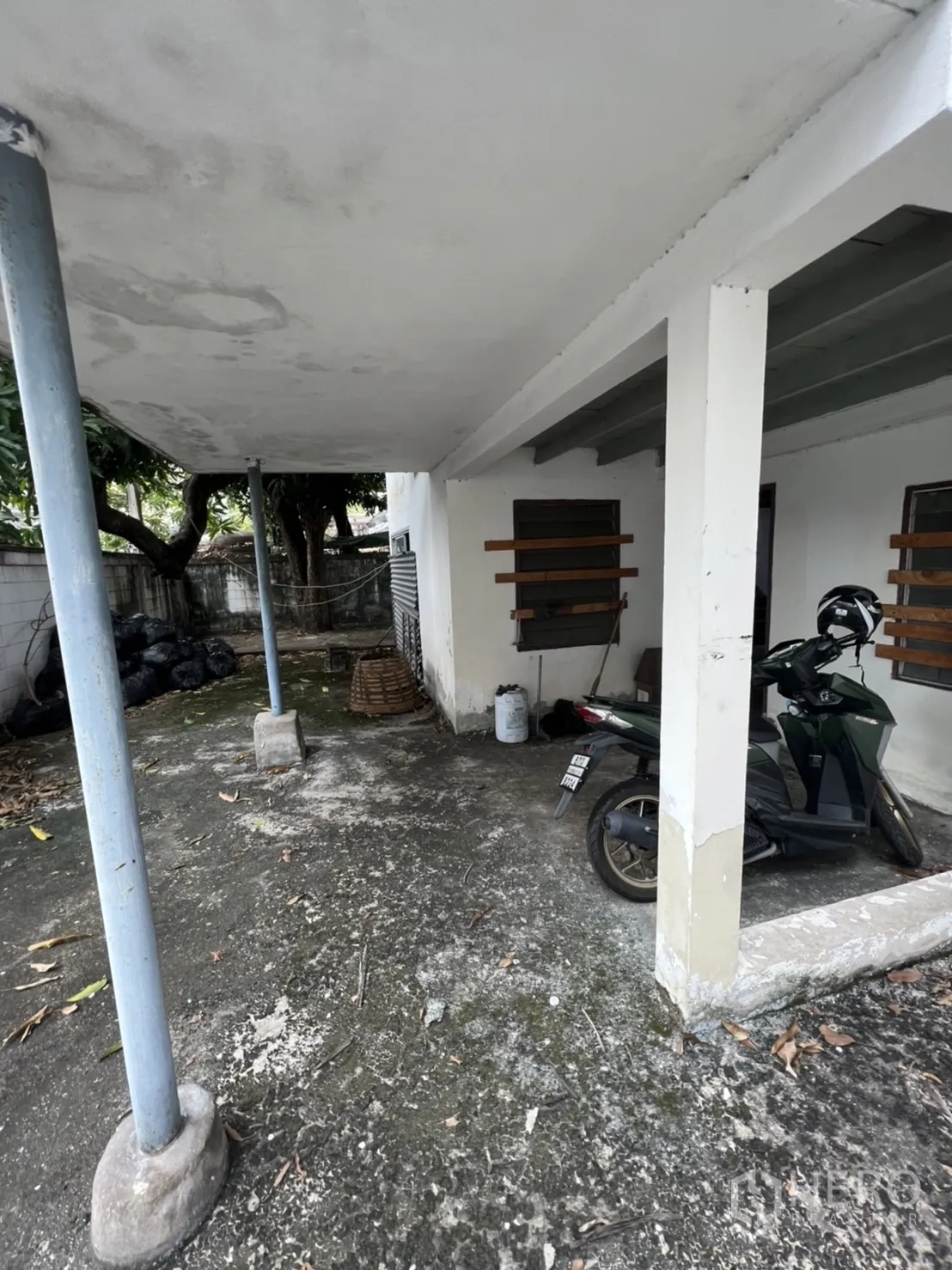 Detached House for rent in Sathon, Bangkok - Covered carport and patio area with concrete floor and support columns.