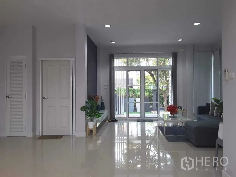 Detached House for rent in Lam Luk Ka, Pathum Thani - Living space opening to the front patio through wide glass doors.