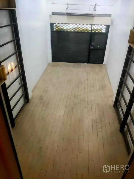 Shophouse for sale in Phra Khanong, Bangkok - Mezzanine view over the long retail floor toward the front shutter.