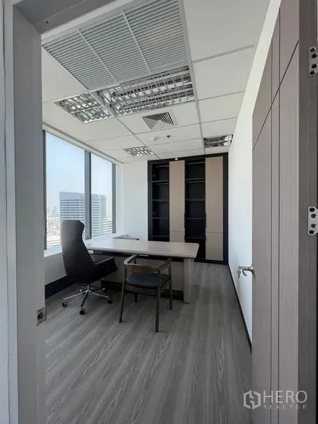 办公空间 出租在Huai Khwang, Bangkok - 独立办公室，配行政桌与内置书柜，大窗可见曼谷天际线。