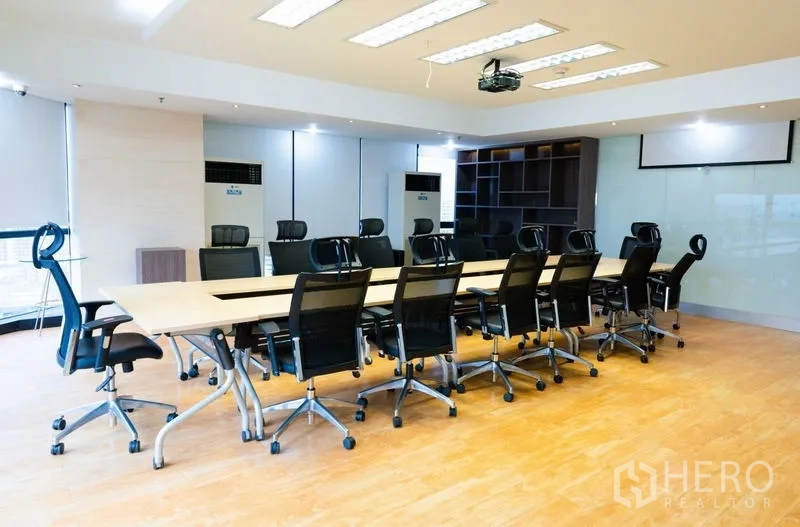 Office Space for rent - Conference room with U-shaped table arrangement, mesh chairs and ceiling projector.