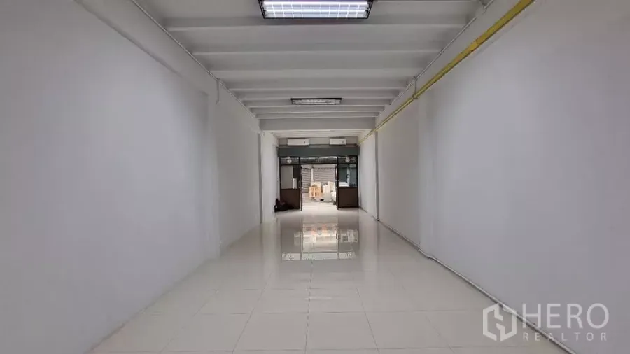 联排别墅 出租在Huai Khwang, Bangkok - 一楼开放式空间，亮白地砖与玻璃门面。