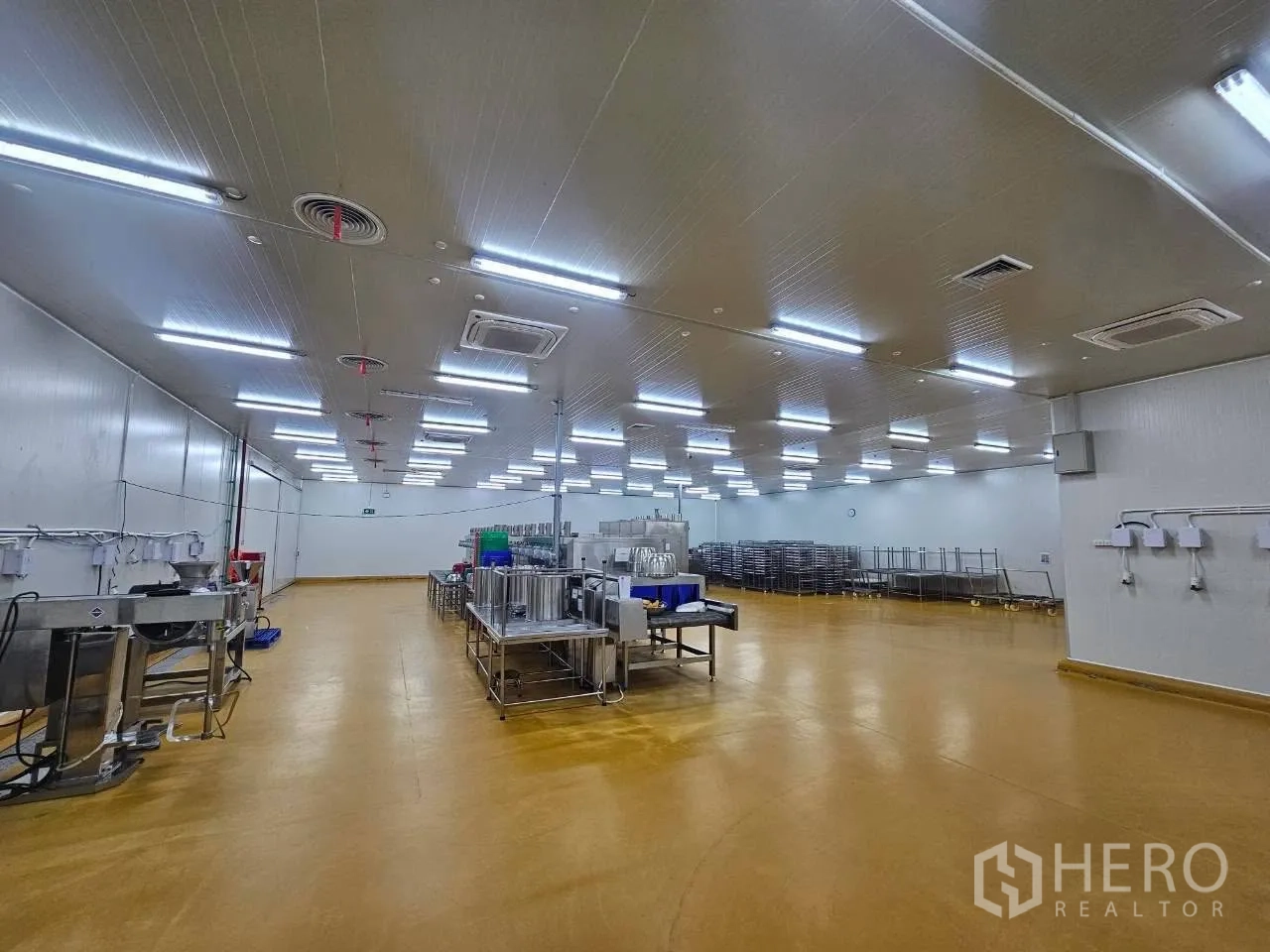 Factory for rent in Mueang Samut Sakhon, Samut Sakhon - Large cleanroom-style hall with equipment, trolleys, and bright lights.
