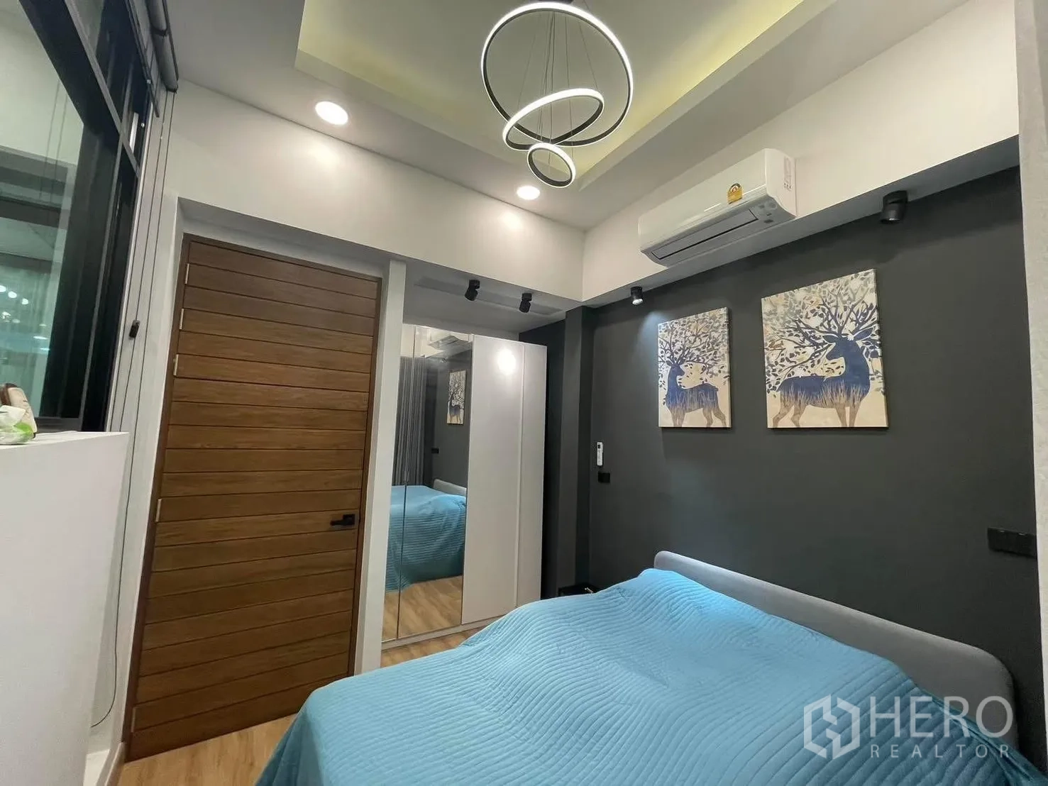 Home Office for rent or sale in Bang Kapi, Bangkok - Cozy bedroom with air-conditioning, artwork, wood door and soft gray tones.