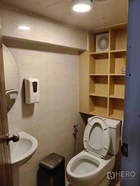 Shophouse for rent or sale in Watthana, Bangkok - Compact restroom with toilet, sink and open shelving.