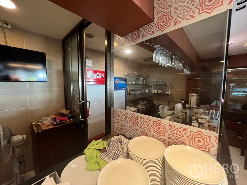 Retail Space for rent or sale in Khlong Toei, Bangkok - Beverage prep corner with hanging glassware racks and a view into the kitchen.