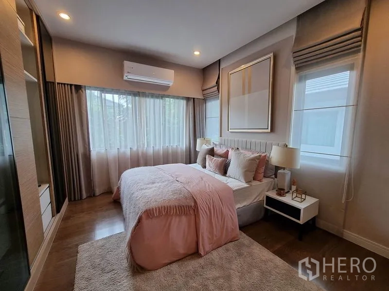 Detached House for rent in Prawet, Bangkok - Inviting bedroom with double bed, soft pink bedding and wide windows with sheer drapes.