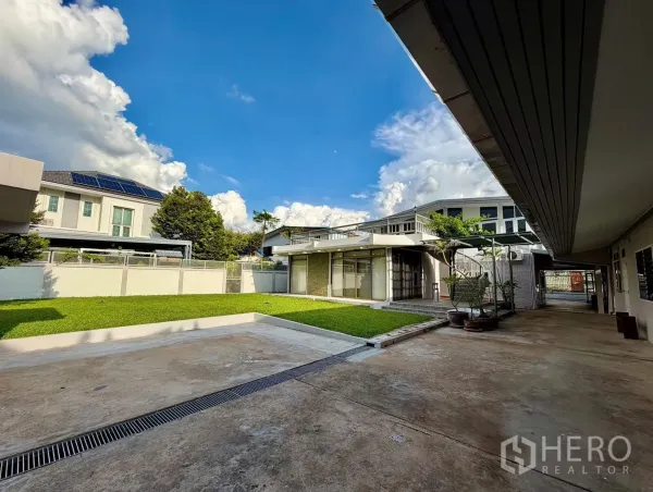 Home Office for rent in Chatuchak, Bangkok - Gated home office compound with landscaped lawn, wide driveway, glass-front building and a covered walkway.