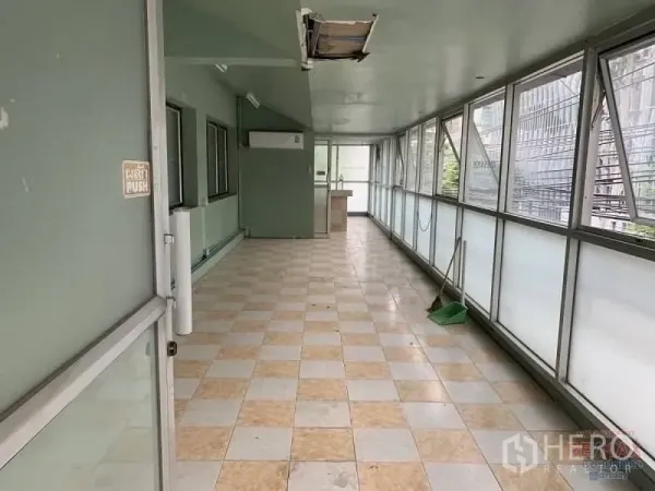 Retail Space for rent in Watthana, Bangkok - Enclosed walkway with large windows and checkerboard tiles, offering bright display space.