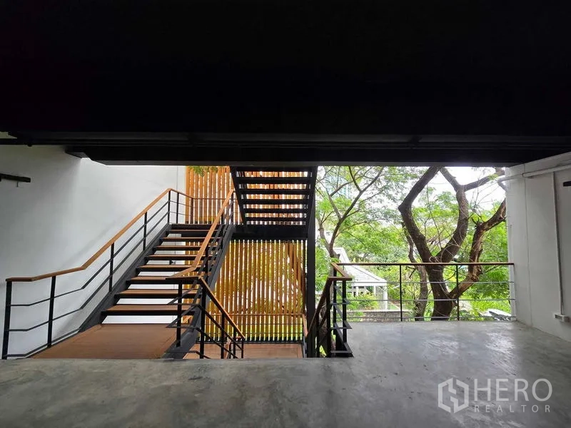 Home Office for rent in Chatuchak, Bangkok - Open terrace view to staircase and wooden privacy screen with garden backdrop.