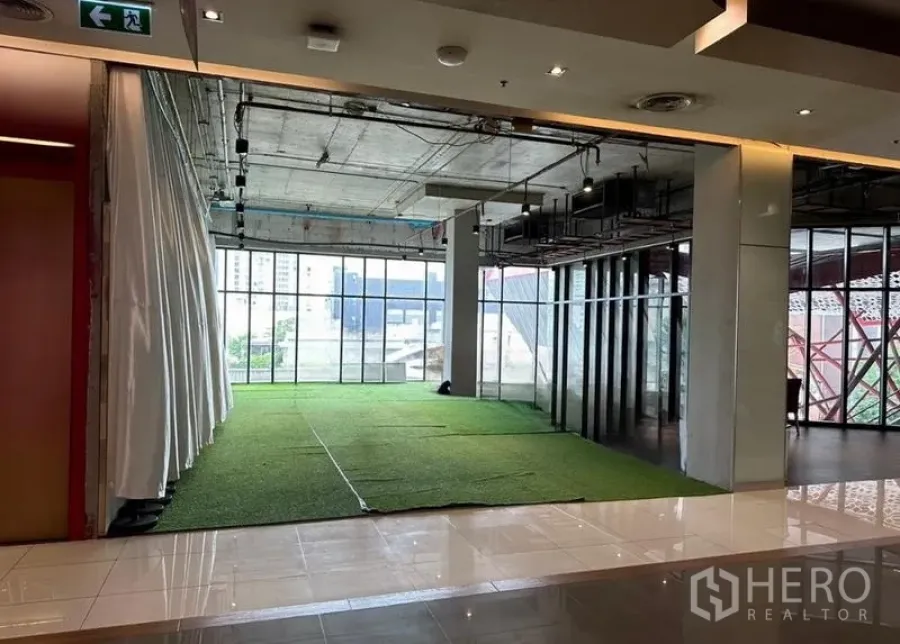 Retail Space for rent in Watthana, Bangkok - Bright retail showroom area with large windows, curtain divider and artificial grass floor.