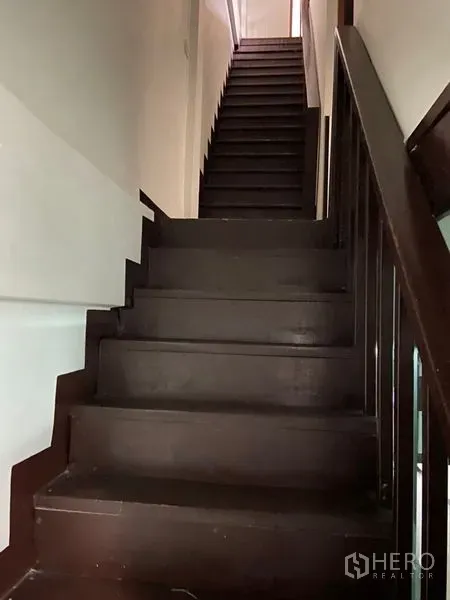 Shophouse for rent in Khlong Toei, Bangkok - Dark wooden staircase leading to the upper floors of the shophouse.