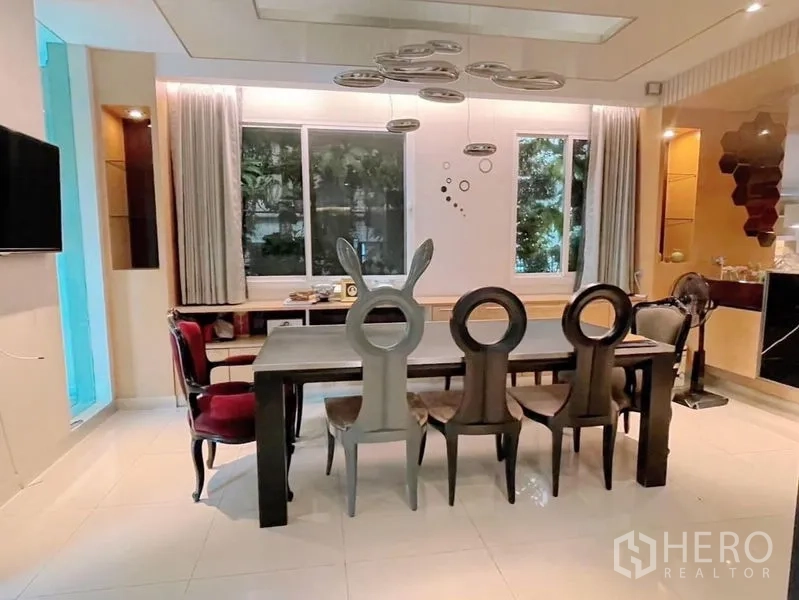 Detached House for rent or sale in Prawet, Bangkok - Dining area with long table, designer chairs and statement pendant lighting by the window.