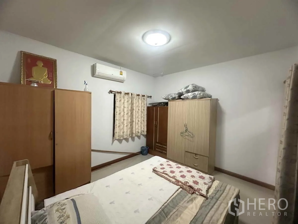 Detached House for sale in Pathum Thani - Bedroom view showing wardrobes, bed and curtained windows.