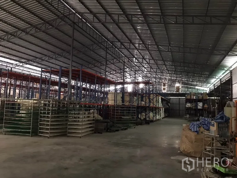 Warehouse for rent in Mueang Chon Buri, Chon Buri - Spacious warehouse interior with high steel truss roof, pallet racking and concrete floor.