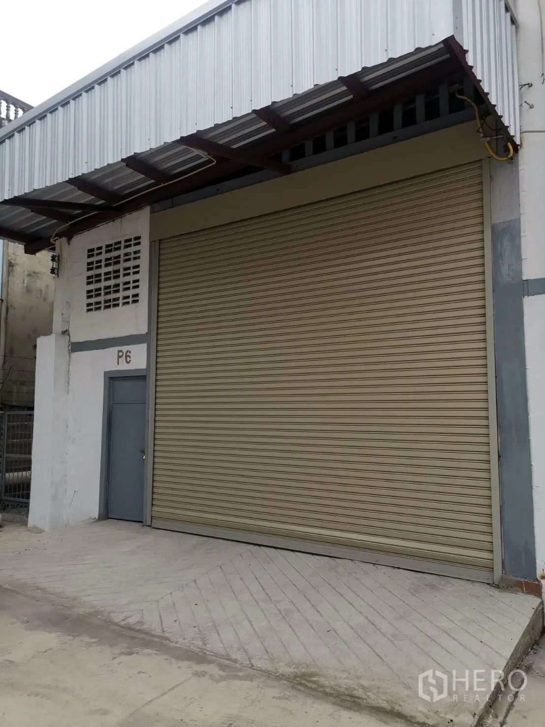 货栈 出租在Suan Luang, Bangkok - 曼谷Suan Luang仓库外观，配大尺寸卷帘门、金属雨棚与侧门。