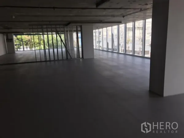 Office Space for rent in Khlong Toei, Bangkok - Open-plan office floor in Phra Khanong with floor-to-ceiling windows, city views, tiled flooring and an exposed ceiling.