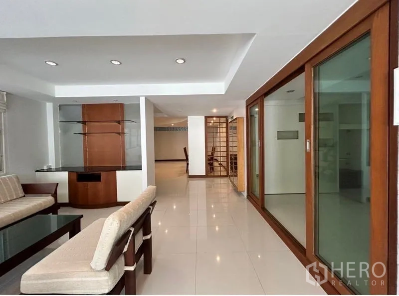 Home Office for rent in Suan Luang, Bangkok - Open-plan living area with wood-framed glass partitions and built-ins.