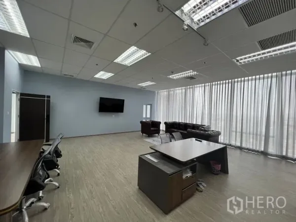 Office Space for rent - Spacious open-plan office with floor-to-ceiling curtains, desk clusters, lounge seating and grid ceiling lights.