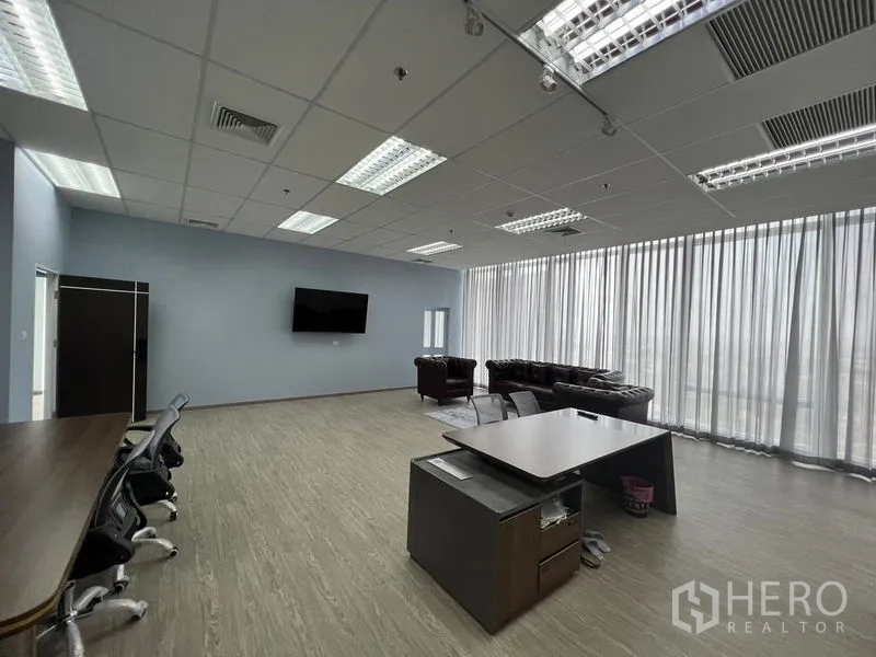 Office Space for rent - Spacious open-plan office with floor-to-ceiling curtains, desk clusters, lounge seating and grid ceiling lights.