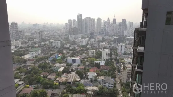 Condominium for rent in Khlong Toei, Bangkok - High-floor balcony view over the Bangkok skyline and surrounding low-rise neighborhood.