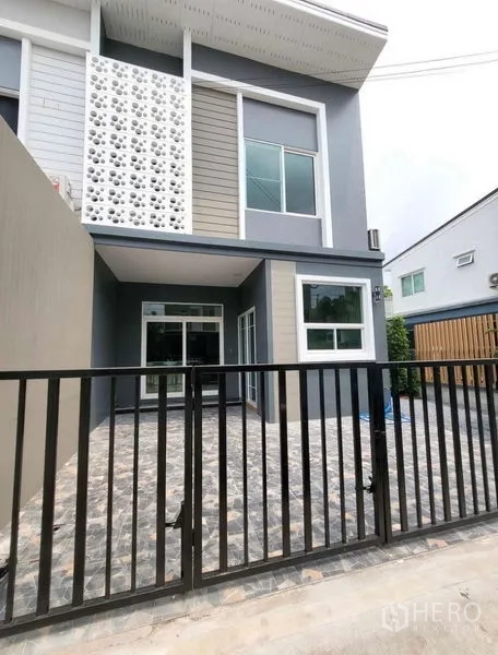 Townhouse for rent or sale - Two-storey townhouse exterior with gated carport, modern façade and sliding glass doors.
