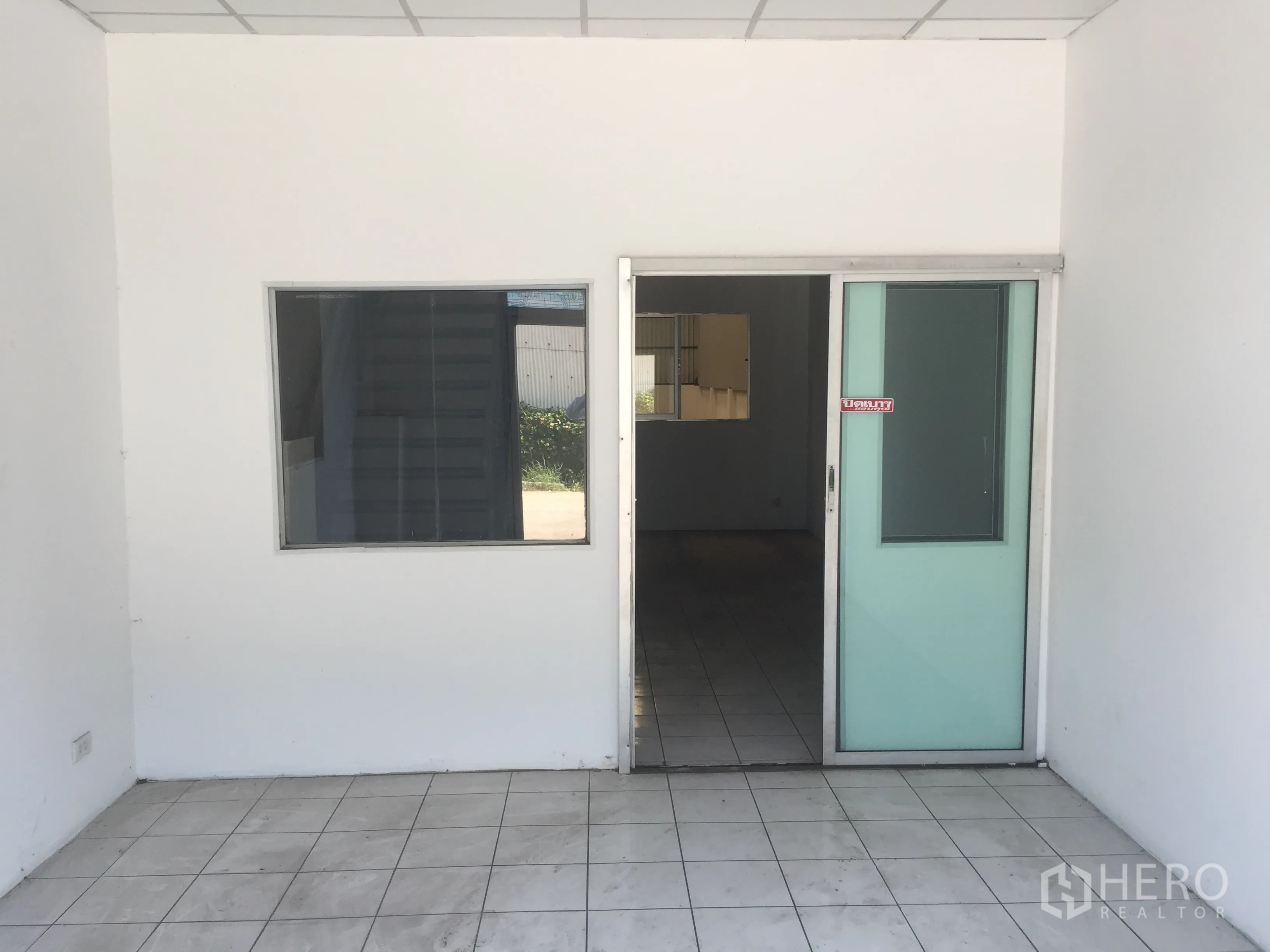 Factory for rent in Khlong Luang, Pathum Thani - Ground-floor office entrance with a sliding glass door and tiled floor.