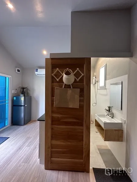 Home Office for rent in Suan Luang, Bangkok - Studio view with kitchenette, fridge and bathroom entrance.