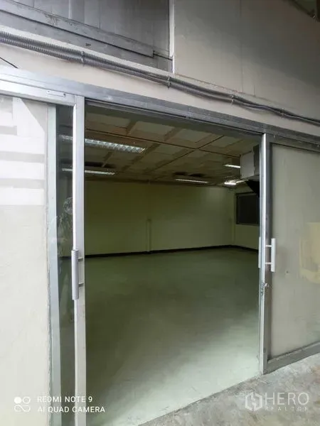 Warehouse for rent in Suan Luang, Bangkok - Glass sliding door opening into a clean office room inside the warehouse.