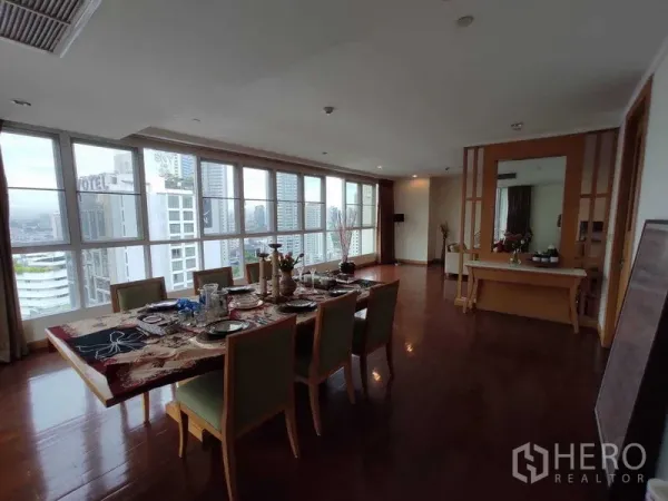 Condominium for rent in Khlong Toei, Bangkok - Long dining room with panoramic windows and Bangkok skyline views.