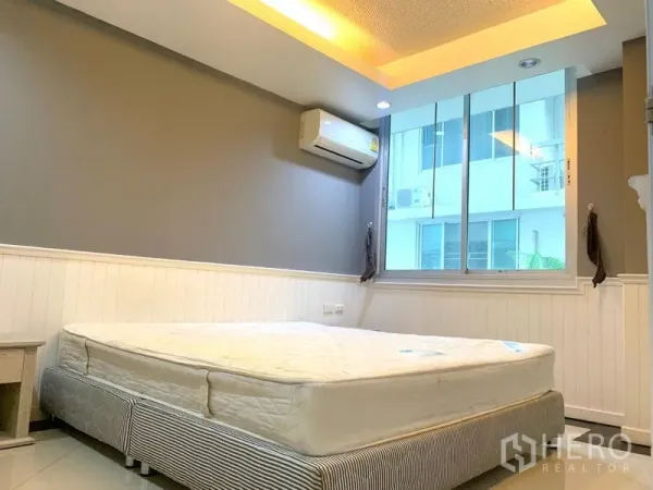 Condominium for rent in Khlong Toei, Bangkok - Bright bedroom with large window, air conditioner and cove lighting at Waterford Sukhumvit 50 near BTS On Nut.