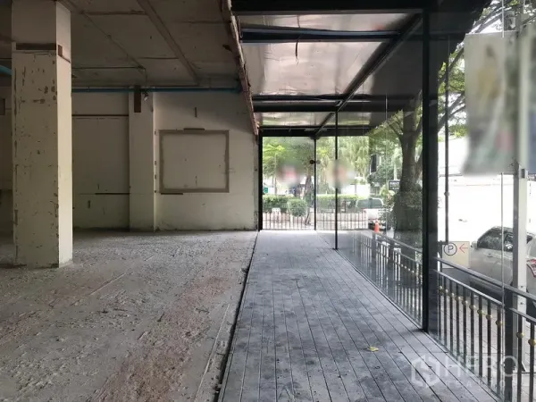 Retail Space for rent in Watthana, Bangkok - Spacious retail floor with floor-to-ceiling windows and a raised walkway to the entrance.