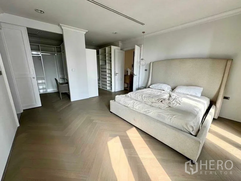 Townhouse for rent in Watthana, Bangkok - Large master bedroom with built-in wardrobes, desk and herringbone floors.