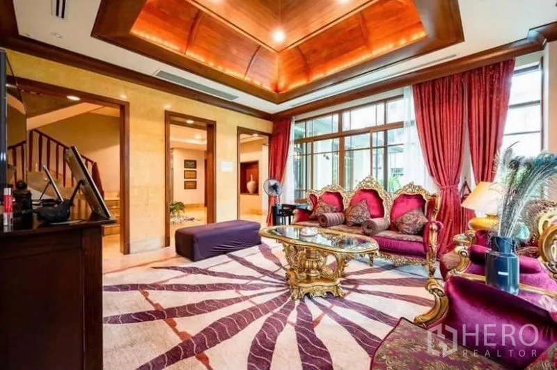 Detached House for rent in Khlong Toei, Bangkok - Grand living room with warm wood coffered ceiling, ornate sofa set and wide windows.