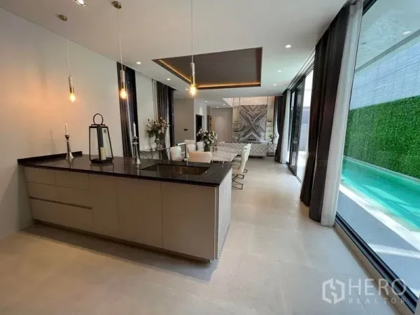 Detached House for sale in Suan Luang, Bangkok - Open-plan living and dining with an island kitchen, floor-to-ceiling glass and pool view in a modern Suan Luang house.