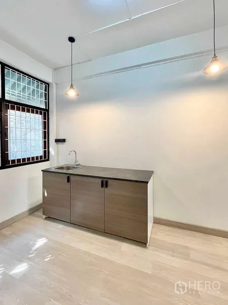 Home Office for rent in Khlong Toei, Bangkok - Compact pantry with sink cabinet and pendant lighting.
