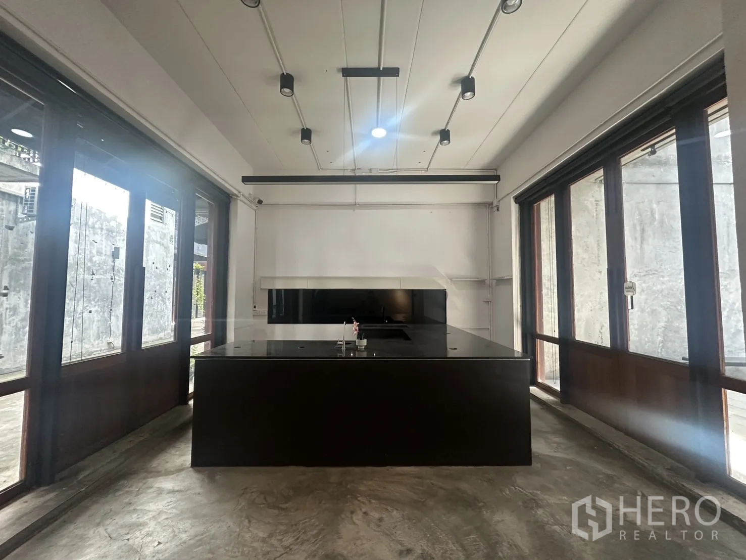 Home Office for rent in Pathum Wan, Bangkok - Central island preparation counter in a light-filled room with sliding glass doors on both sides.