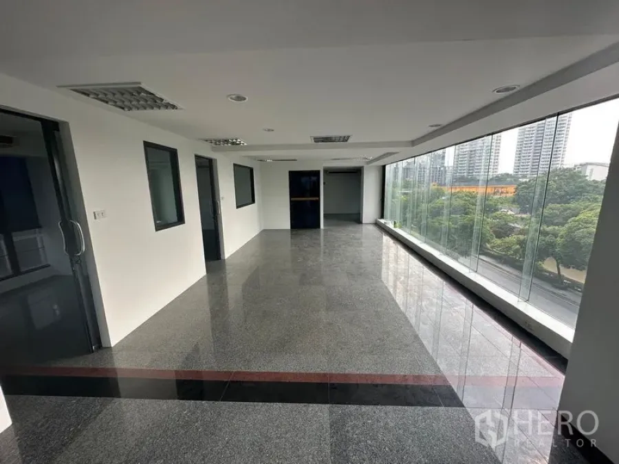 Office Space for rent in Sathon, Bangkok - Open office floor with floor-to-ceiling windows facing greenery and the Bangkok skyline.