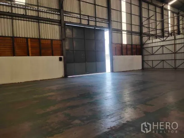 Warehouse for rent in Mueang Samut Sakhon, Samut Sakhon - Interior view toward wide sliding steel door allowing truck access to the floor.