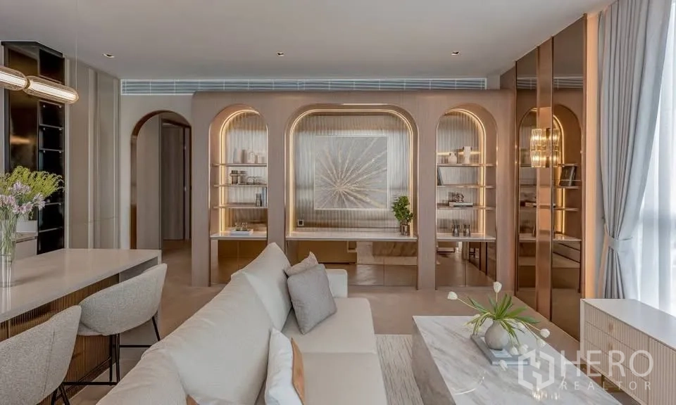 Condominium for rent in Sathon, Bangkok - Living room featuring arched built-in shelving, a marble coffee table, and large windows.