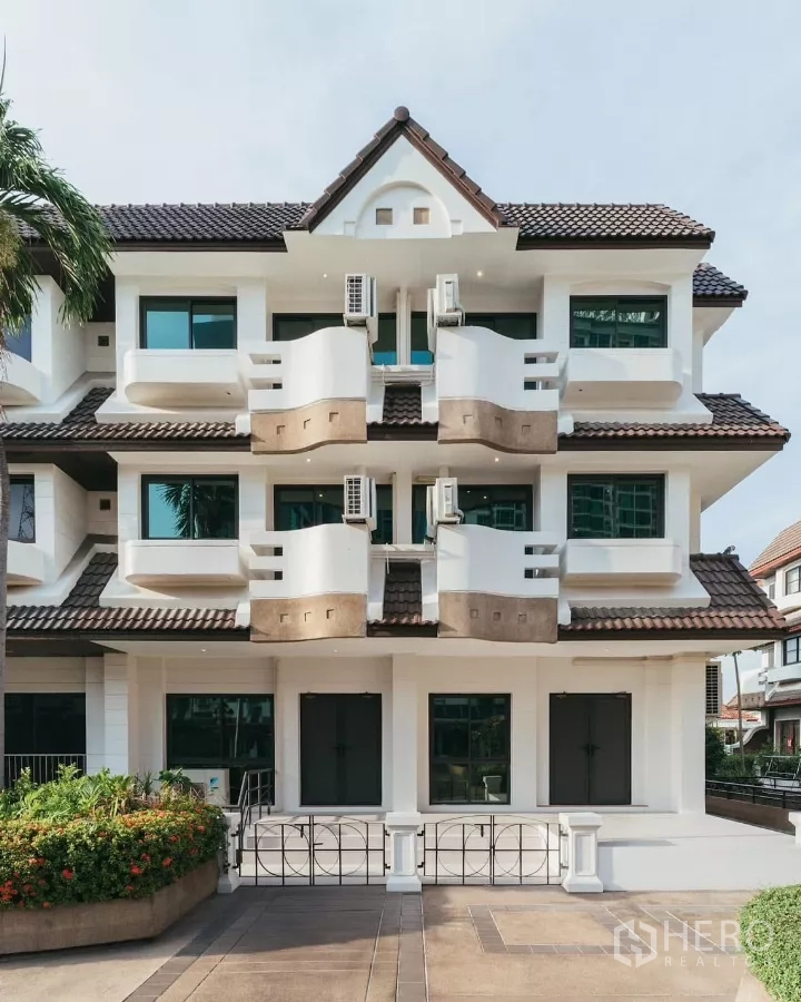 Townhouse for rent in Watthana, Bangkok - Three-storey modern townhouse facade with balconies and tiled roof in Watthana, Bangkok.