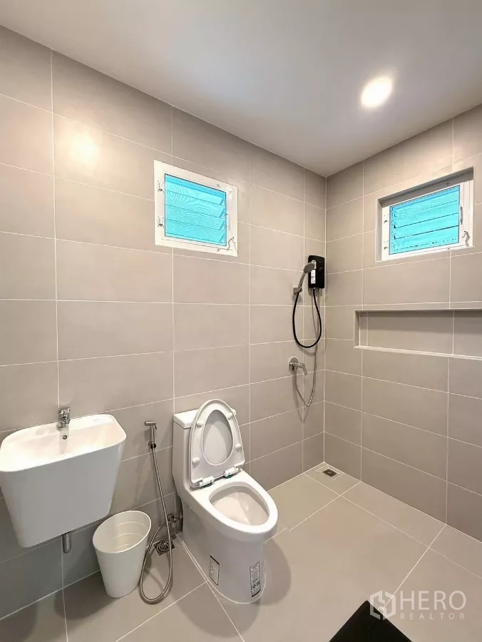 Detached House for rent in Bang Phli, Samut Prakan - Large tiled bathroom with toilet, hand shower and dual windows.